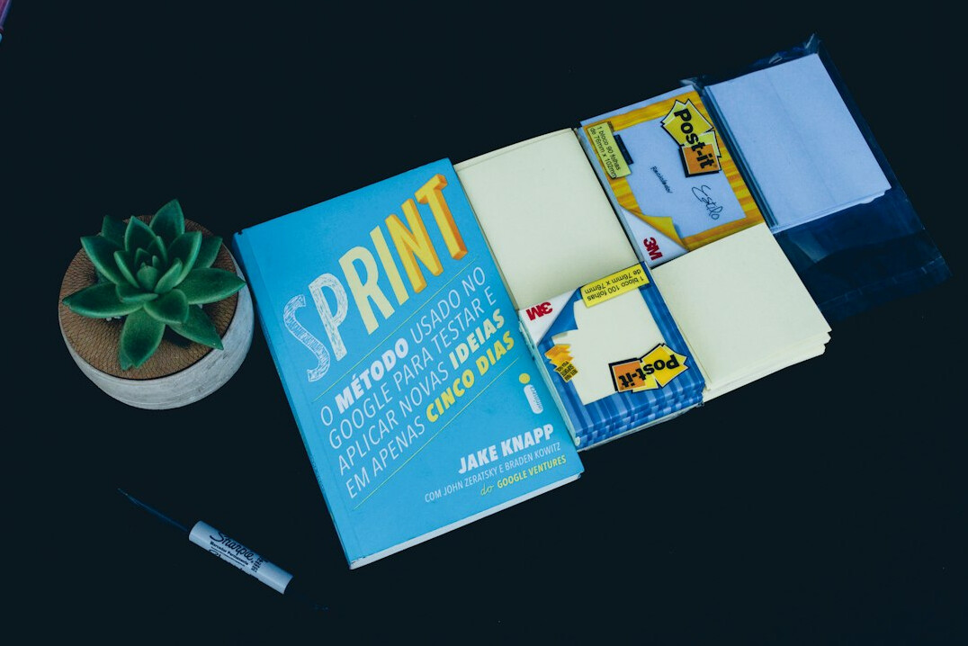 Stack of programming books with an open notebook showing hand-drawn diagrams