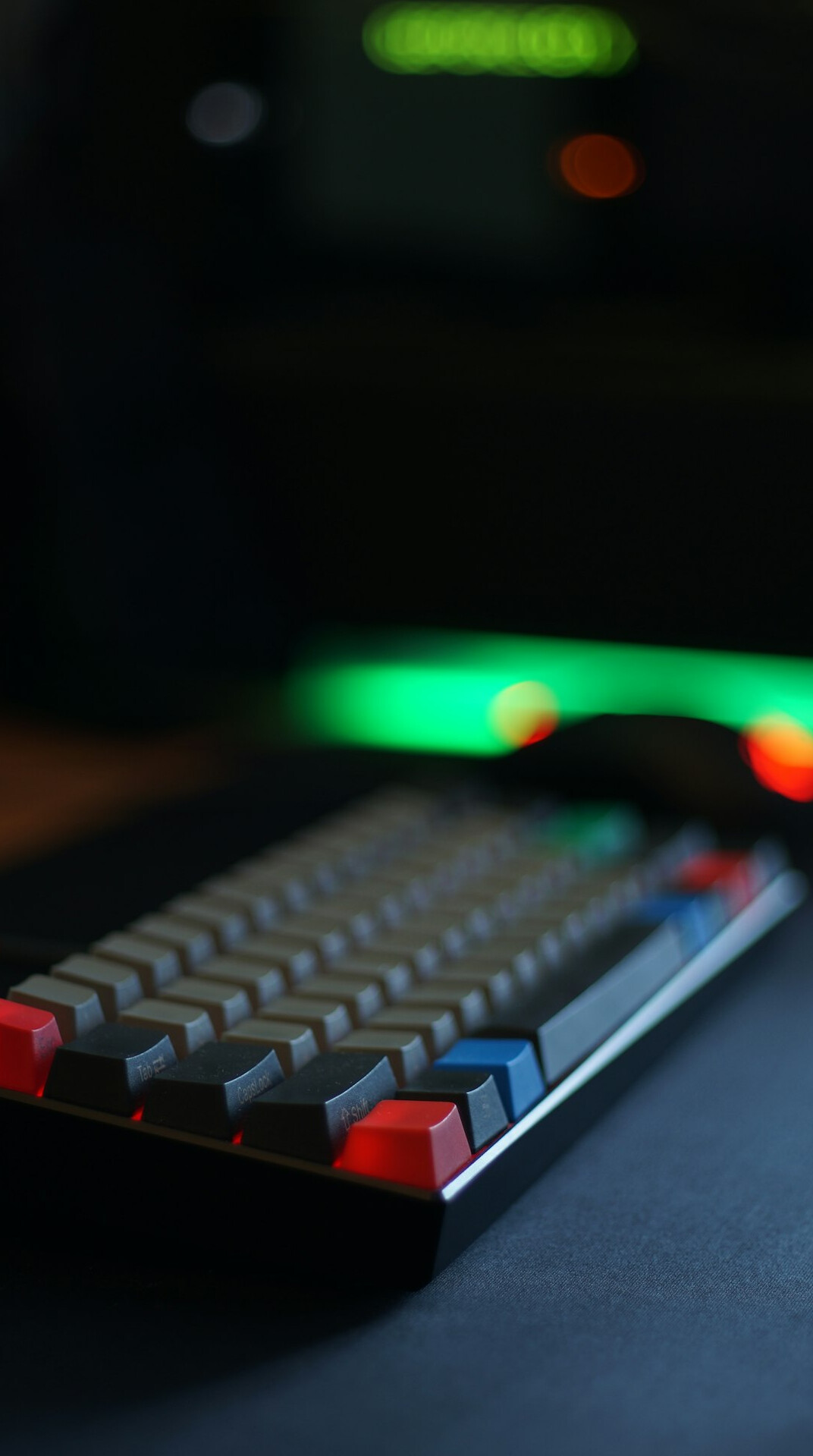 Close-up of a mechanical keyboard with a blurred code editor in the background